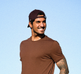 Gabriel Medina sorrindo em um fundo ensolarado