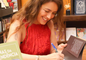 Manuela Dias escrevendo em um livro